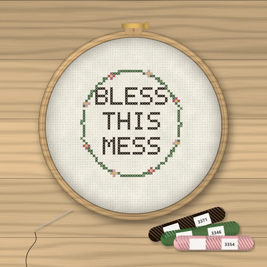 Bless This Mess cross stitch finished in a wooden embroidery hoop with DMC thread skeins