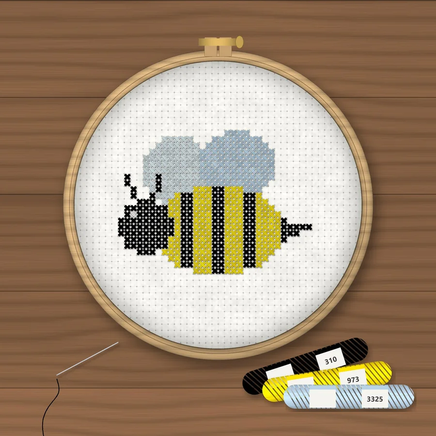 Bumble Bee cross stitch finished in a wooden embroidery hoop with DMC thread skeins