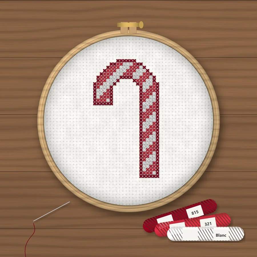 Candy Cane cross stitch finished in a wooden embroidery hoop with DMC thread skeins
