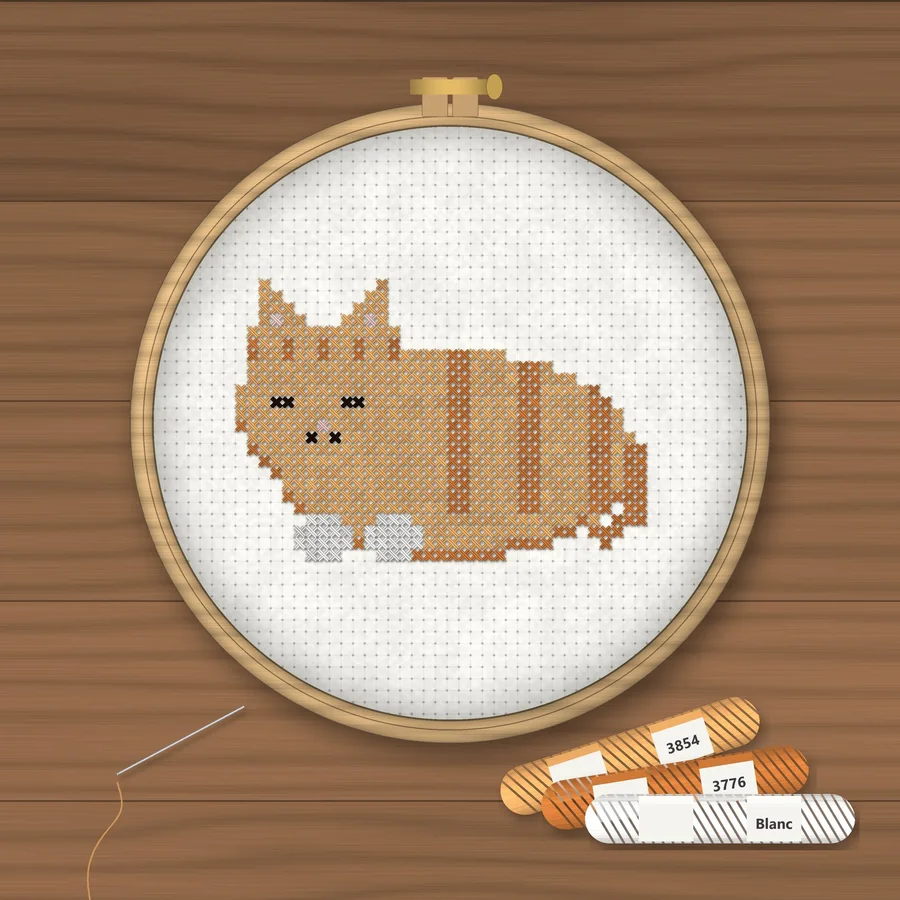Orange Cat Loaf cross stitch finished in a wooden embroidery hoop with DMC thread skeins