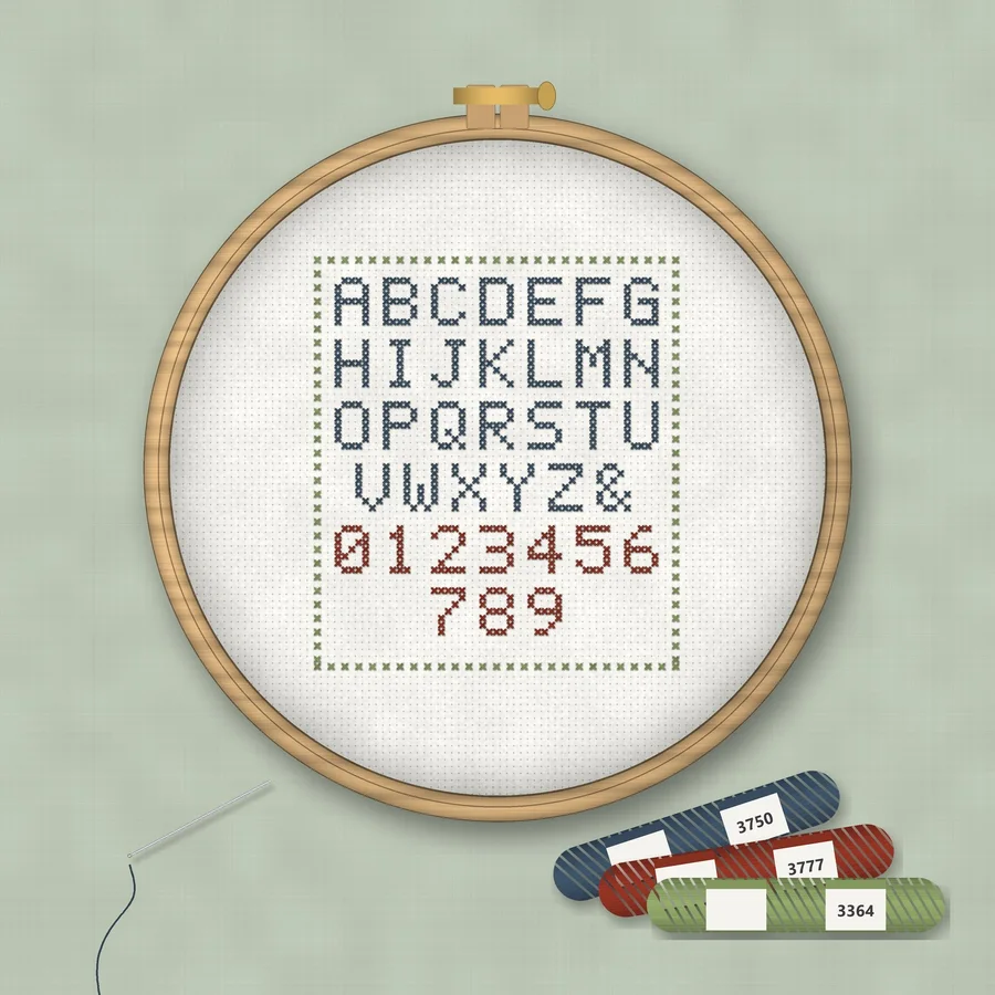 Cross Stitch Alphabet Pattern cross stitch finished in a wooden embroidery hoop with DMC thread skeins