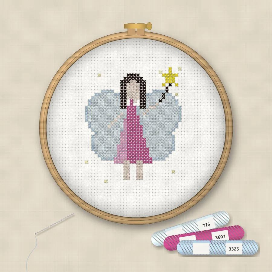 Fairy cross stitch finished in a wooden embroidery hoop with DMC thread skeins