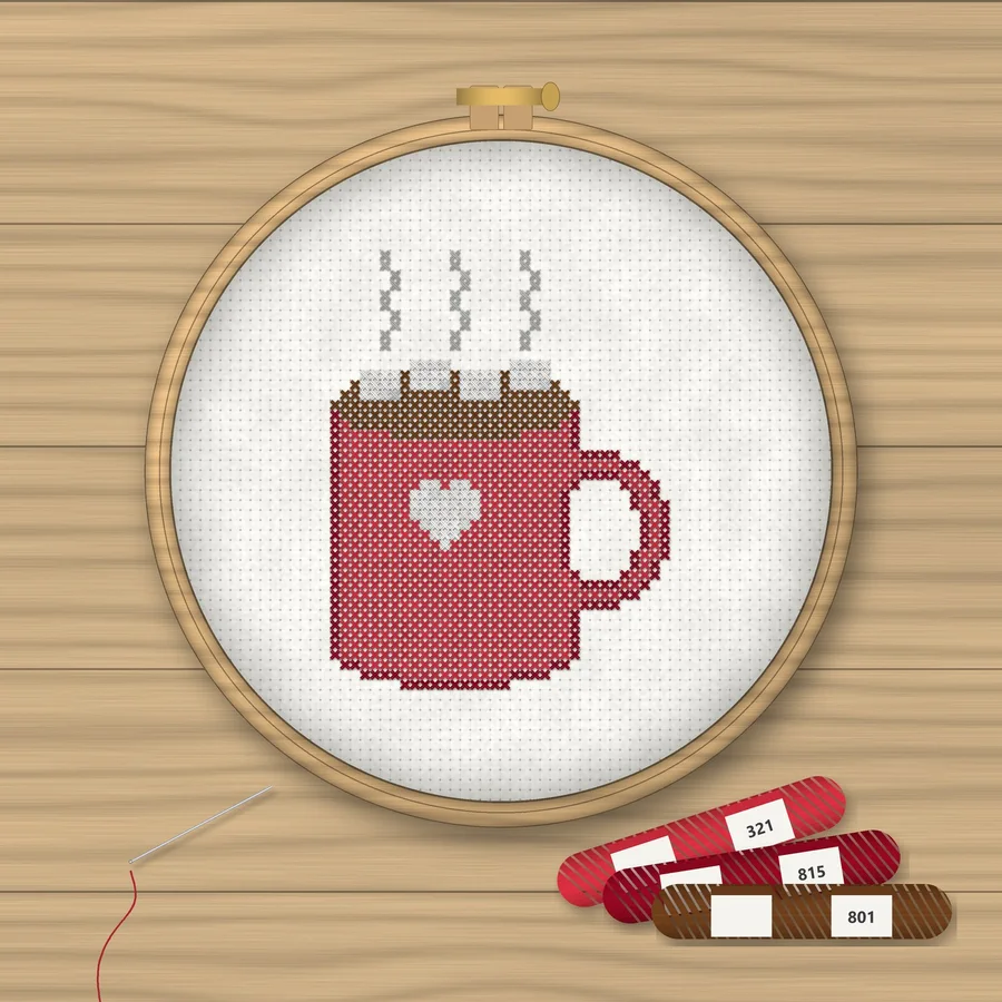 Hot Cocoa cross stitch finished in a wooden embroidery hoop with DMC thread skeins