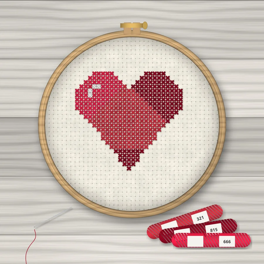 Red Heart cross stitch finished in a wooden embroidery hoop with DMC thread skeins
