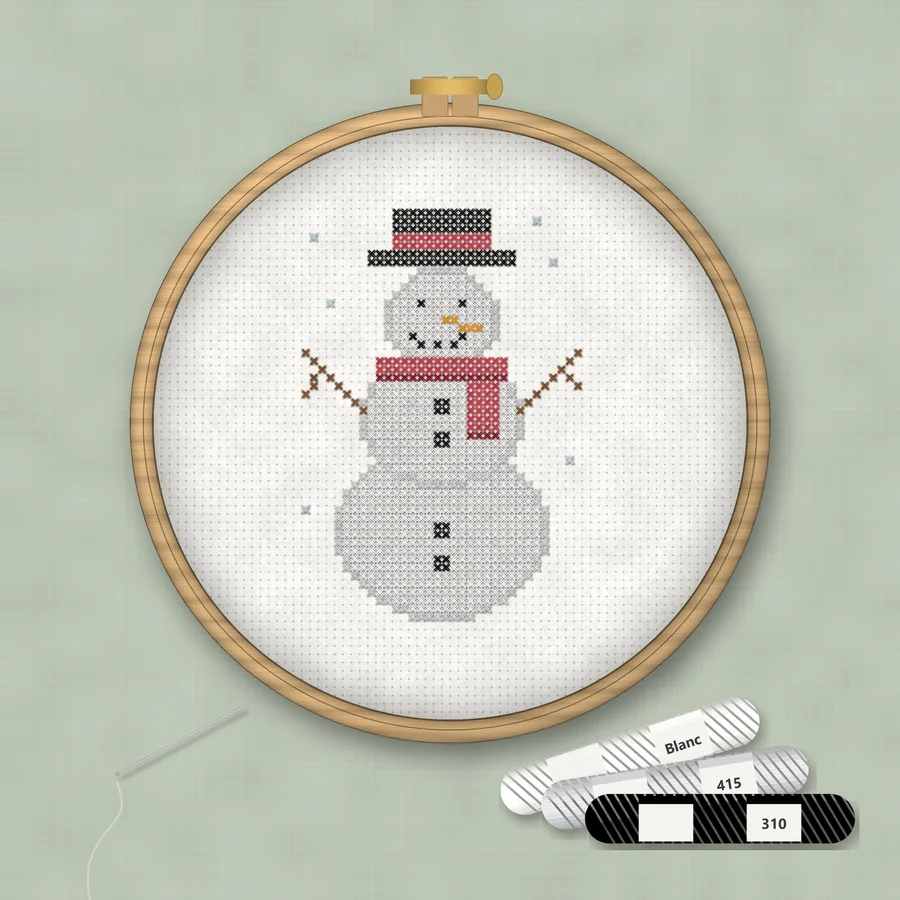 Snowman cross stitch finished in a wooden embroidery hoop with DMC thread skeins