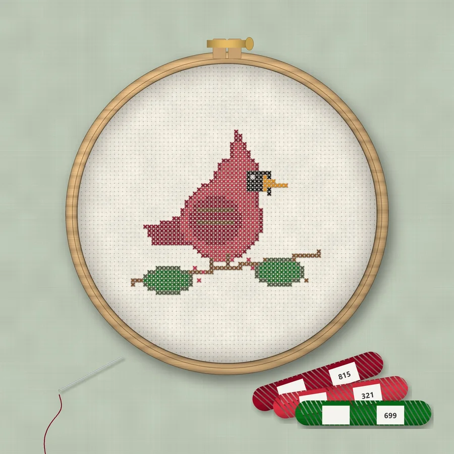 Winter Cardinal cross stitch finished in a wooden embroidery hoop with DMC thread skeins